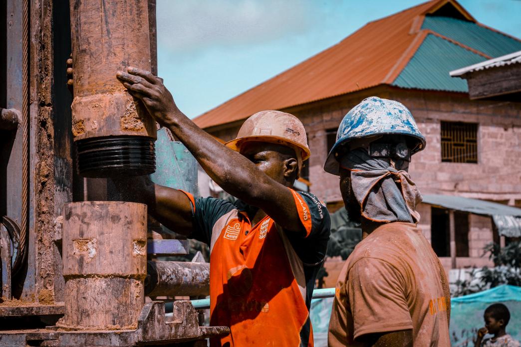 Workers putting together a drill in Ghana