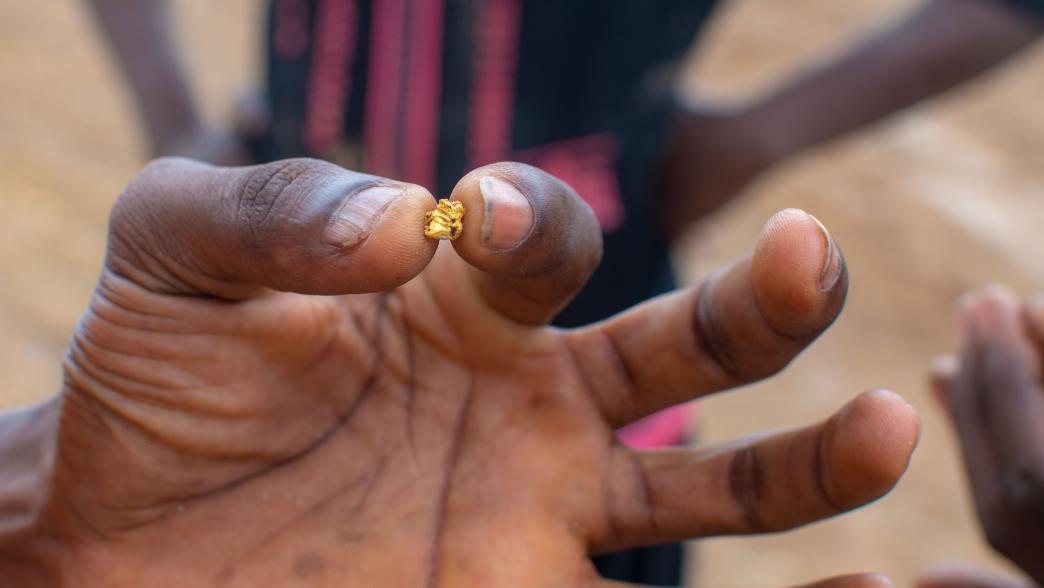 Ghanaian miner holding a small nugget of gold
