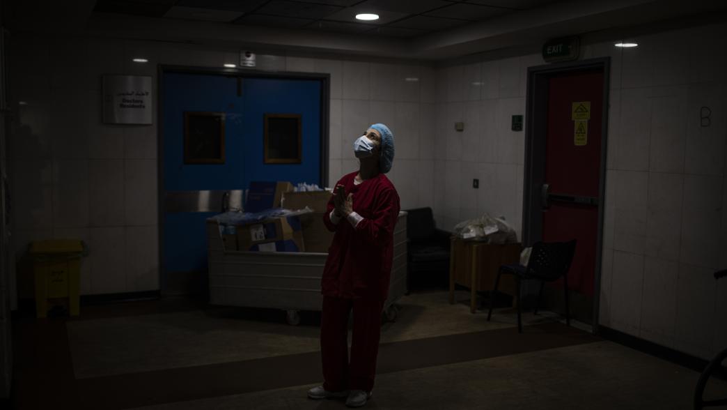 Lebanese nurse in a mask in a dark hospital room, Beirut, Lebanon