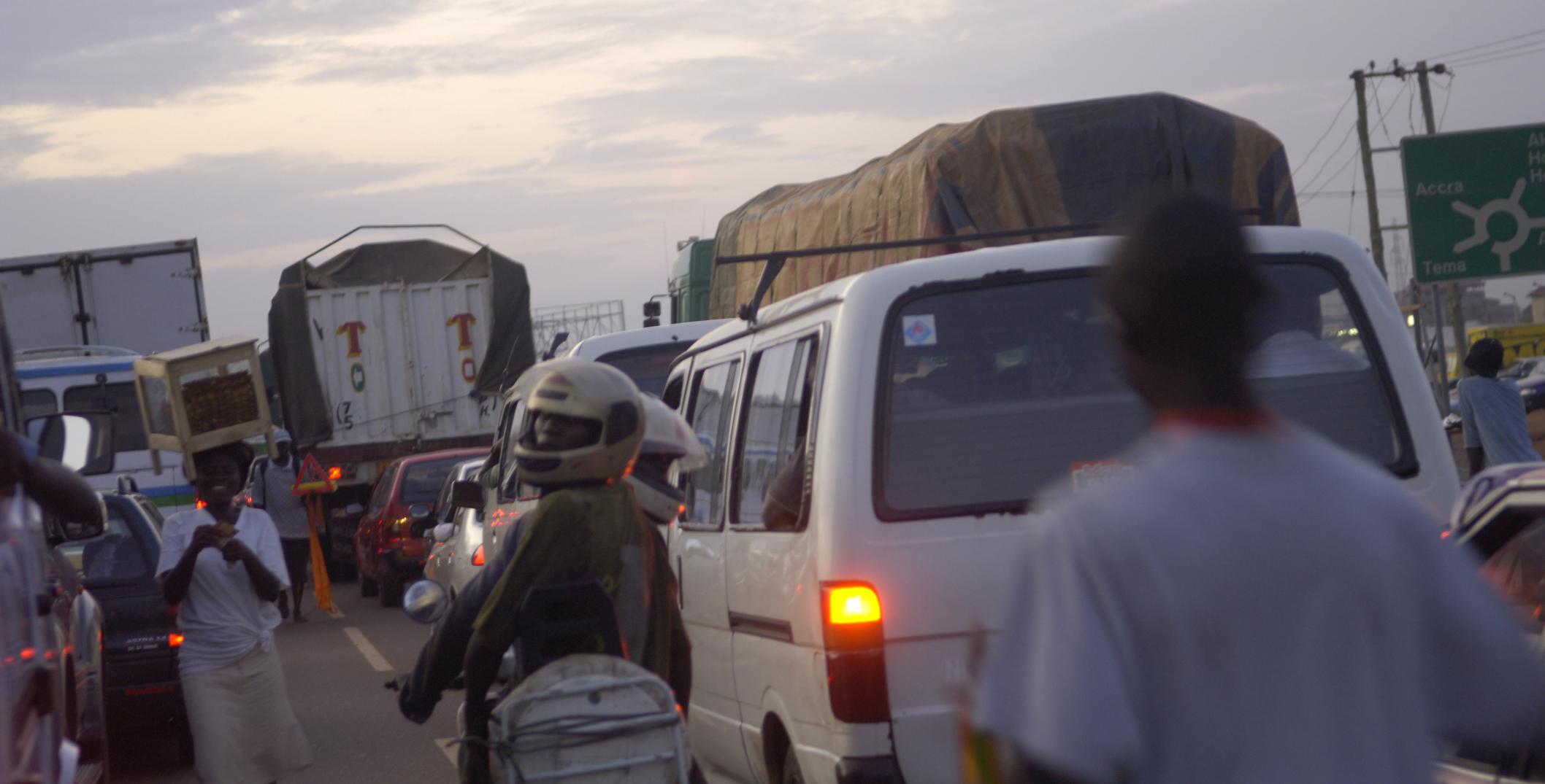 Traffic in Ghana with vendors working between vehicles