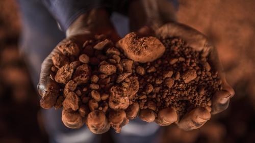 Hands holding bauxite in Guinea