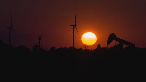wind turbines with pumpjack at sunset