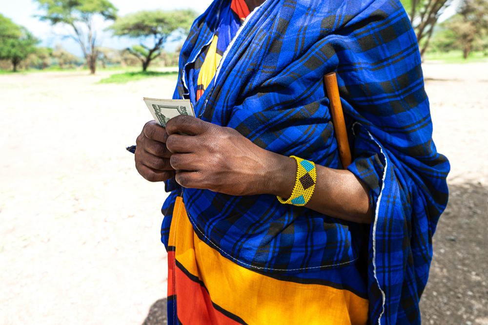 Man in Tanzania counting money, counting dollars